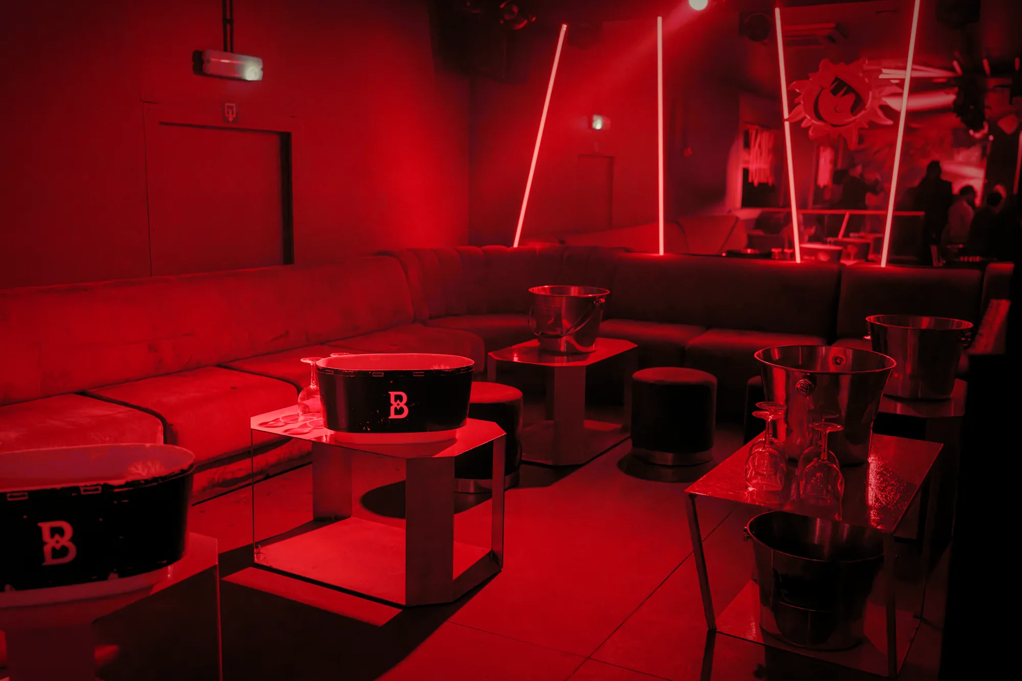 Red lounge at Birdy with tables and ice buckets marked B