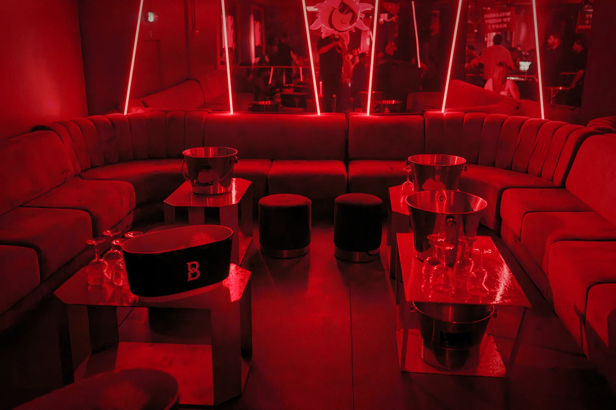 Red velvet banquettes and ice buckets in the Birdy lounge