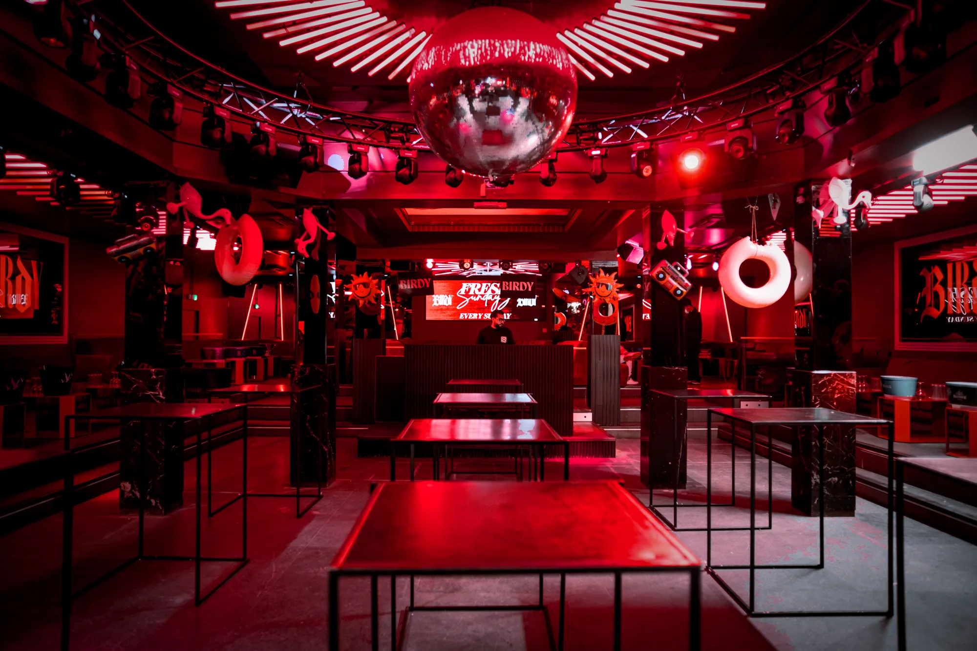 Birdy main room in red light with mirror ball and DJ booth, nightclub in Brussels